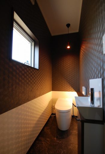 まるで店舗のトイレのような設え。こちらもモノトーンでまとめ、間接照明でのライティング。