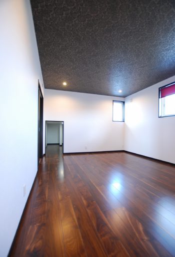 寝室の天井にはシックなデザインクロスをセレクト。奥の小さな入り口をくぐると小屋裏を利用した収納庫が!空間を最大限に活用。